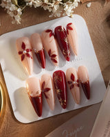 Crimson Petals press-on nails with red French tips, gold outlines and fall floral accents