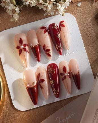Crimson Petals press-on nails with red French tips, gold outlines and fall floral accents