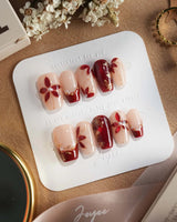 Crimson Petals press-on nails with crimson red French tips and gold outlined floral accents