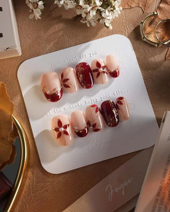 Crimson Petals press-on nails with deep crimson tips and delicate gold outlined flowers