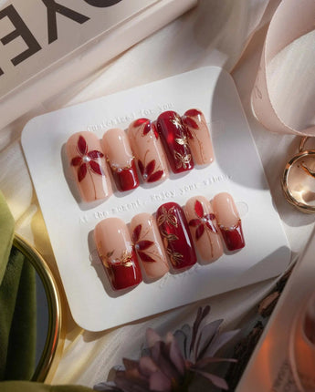 Crimson Petals medium square press-on nails with red French tips and gold floral accents