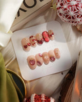 Crystal Berry press-on nails with deep red cat-eye shine, cherry accents and dimensional gel finish