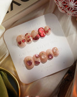 Crystal Berry press-on nails with red berry cat-eye shimmer, nude base and gold line accents