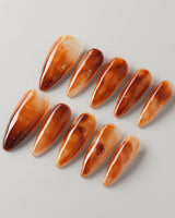 Onyx Shine press-ons with amber brown marble effect and smooth glossy finish
