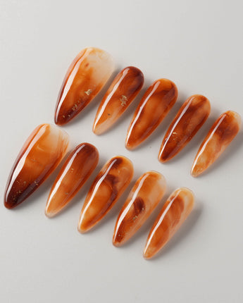Onyx Shine press-ons with amber brown marble effect and smooth glossy finish