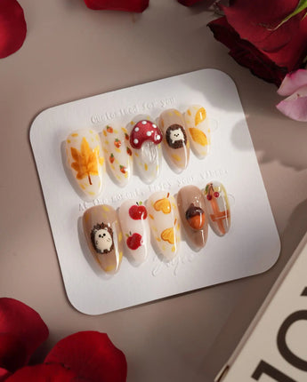 Cute Hedgehog press-on nails with warm fall colors, bow details, and woodland nail art