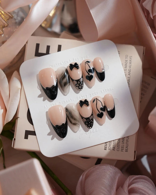 Dark Cherry handmade press-on nails featuring Chic Black & Nude, Lace Bows, Ink Marble Swirls & Glitter Heart Cherries.