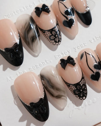 Dark Cherry nail art close-up showing Chic Black & Nude, Lace Bows, Ink Marble Swirls & Glitter Heart Cherries. details