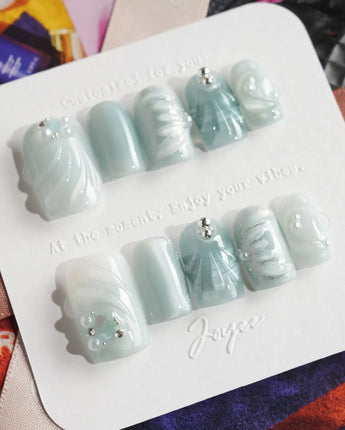 Dead Sea Blue press-ons with jelly gloss, silver dust, and ocean-inspired shell details