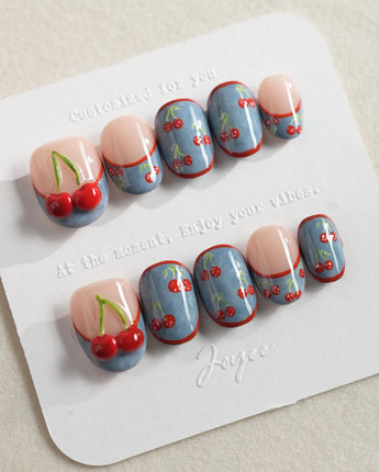 Denim Cherry Y2K press-on nails with playful cherries and blue denim-tip contrast