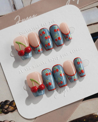 Denim Cherry handmade nails with nude base, denim blue accents, and glossy cherry art