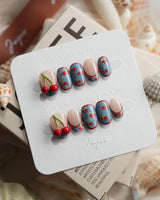 Denim Cherry short oval nails with denim-textured tips and hand-painted cherry accents