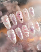 Dreamglow short almond nails with pearly pink base, 3D bows, and pearl accents