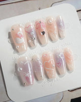 Dreamglow handmade nails with pearly pink shimmer, bow accents, and soft romantic glow