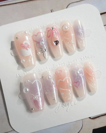 Dreamglow handmade nails with pearly pink shimmer, bow accents, and soft romantic glow