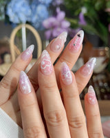 Dreamglow close-up of pearly pink nail art with raised bows and pearl details