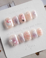 Dreamglow summer nails with soft pink glow, pearl embellishments, and sculpted bows