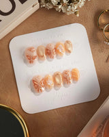 Dreamland Glow press-on nails with gold butterfly reliefs and elegant bridal fall styling