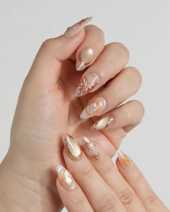 Dreamland Glow press-on nails with gold 3D butterfly details and soft wedding-inspired shimmer