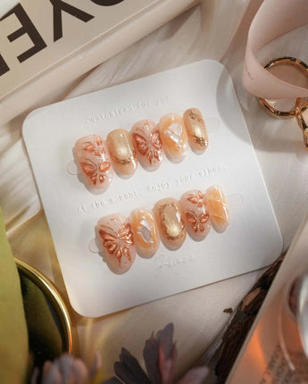 Dreamland Glow short oval press-on nails with gold 3D butterfly accents and bridal shimmer