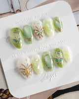Dreamland green butterfly press-on nail set with layered shimmer and vine linework