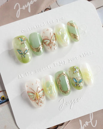 Dreamland sage green cat-eye nails with chrome vines and glowing butterfly art