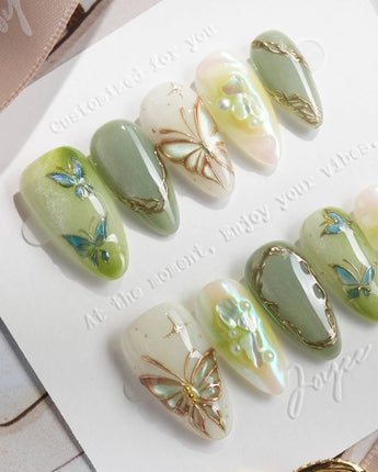 Dreamland sage green press-on nails with glowing cat-eye gradients and gold details