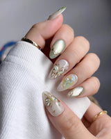 Dreamland glossy green press-on nails with layered butterfly wing glow