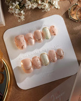 Earthy glow press-on nails with nude peach gel, gold leaf accents and glossy finish