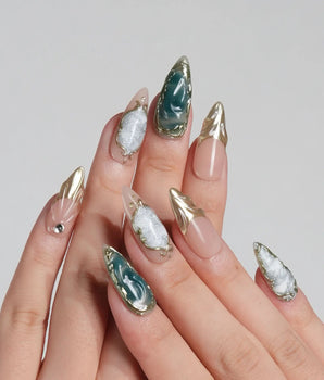 Electric Muse press-on nails with emerald green cat-eye shimmer and gold-framed nude accents