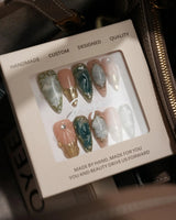 Electric Muse press-on nails with emerald green cat-eye marble, gold frames and sculpted glossy details