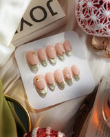 Silk Green - New nail art close-up showing nude pink base sage green french gold outline pearl studs cat eye effect details
