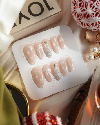 Snowfall nail art close-up showing pearl nude cat eye snowflake bow silver glitter soft sheen details