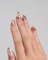 Caramel Cream nails with soft brown gel color, sculpted floral accents, and gold details