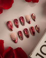 Molten Rouge press-on nails with glossy red cat-eye shimmer and gold outlined nude accents