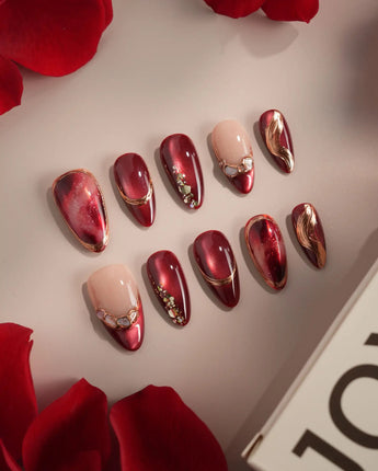 Molten Rouge press-on nails with glossy red cat-eye shimmer and gold outlined nude accents
