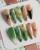 Emerald - Jade Sutra press-on nails in long stiletto shape — Elegant Grape Green, Marble Smudge & Liquid Metal.