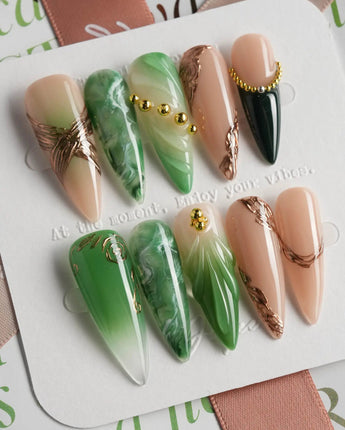 Emerald - Jade Sutra press-on nails in long stiletto shape — Elegant Grape Green, Marble Smudge & Liquid Metal.