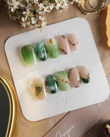 Emerald - Jade Sutra press-on nails in short oval shape — Elegant Grape Green, Marble Smudge & Liquid Metal.