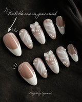 Engagement nail art close-up showing Elegant Style, Pearl Outlines & 3D Ribbon Bows. details