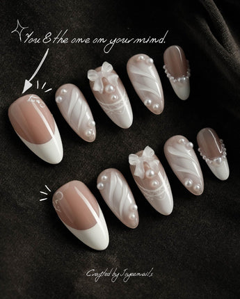 Engagement nail art close-up showing Elegant Style, Pearl Outlines & 3D Ribbon Bows. details