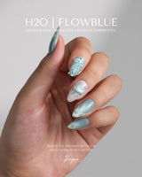 Exuma Blue glossy light blue nails with heart charms, ripple texture, and silver foil