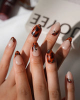 Handmade Pumpkin Patch press-on nail set with nude base amber tortoise swirls and gold accents