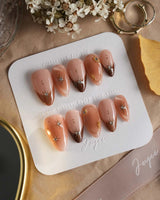 Fall Makeup nails with glossy brown gradient, 3D gold stars, and delicate gem placement