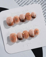 Fall Makeup press-on nails with warm caramel base, gold wire star art, and glossy shine