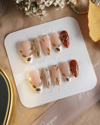 Falling leaves press-on nails with raised gold leaf reliefs and soft caramel fall styling