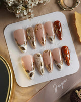 Falling leaves press-on nails with caramel autumn palette and raised gold vine accents