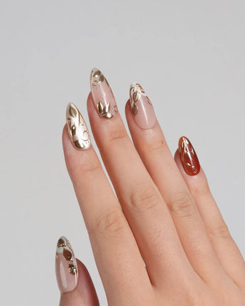 Falling leaves press-on nails with raised gold leaves, warm caramel tones and glossy finish