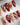 Festive red and gold nails with cat-eye shimmer and holiday accents