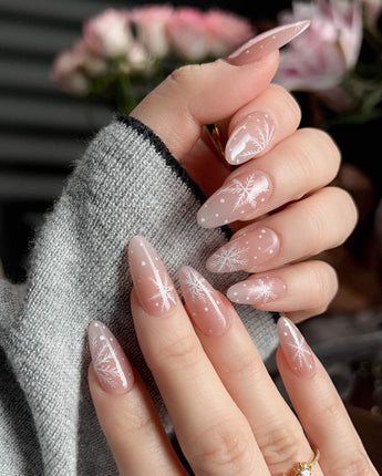 Frost Petals handmade press-on nails featuring Sheer Nude Pink, Delicate White Snowflakes.